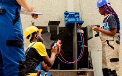 Three AC technicians refill the freon in the AC.