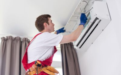 A technician performing air conditioning repair service on a modern indoor unit.
