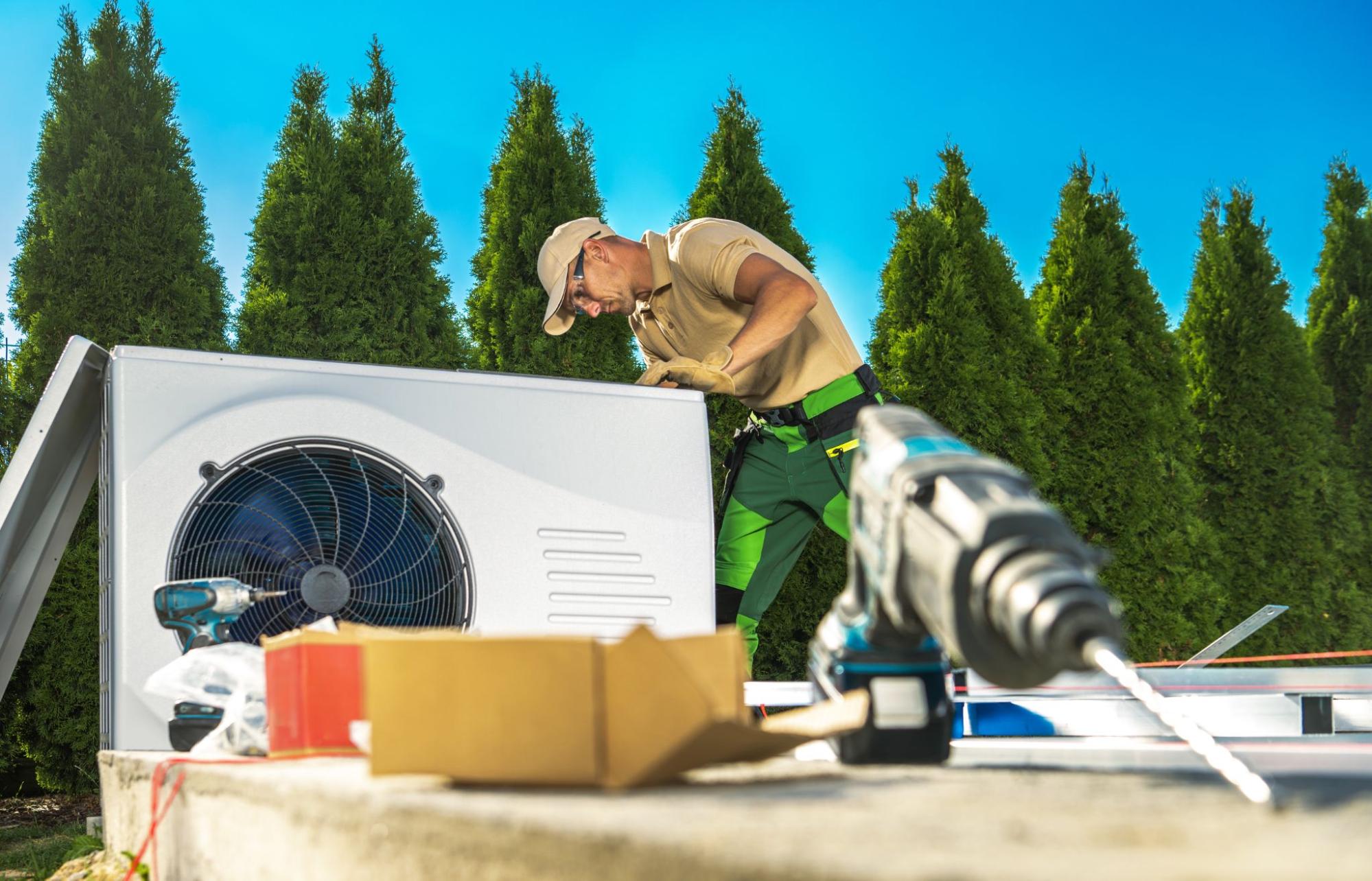 An AC Installer working on an air conditioner outside in the background with tools in the foreground.