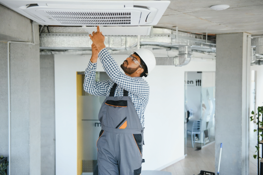 A professional HVAC technician performing AC repair on a modern indoor unit